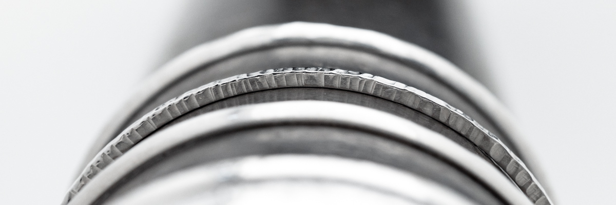 Hammered textured silver bangles on a mandrel