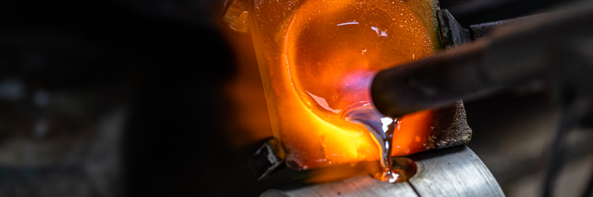 Molten silver being melted with a torch and poured from a crucible